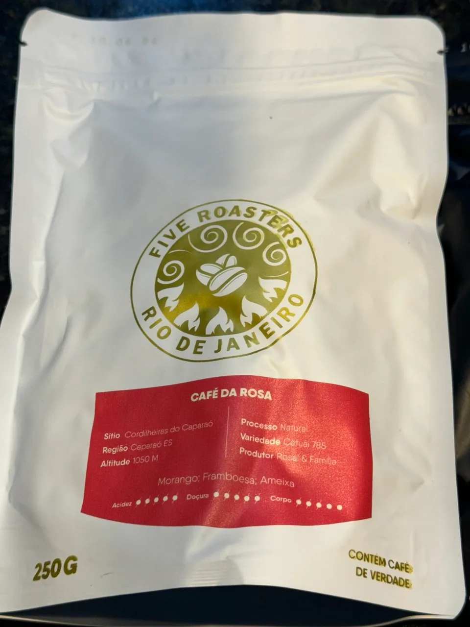 Embalagem branca do Café da Rosa, da Five Roasters, com rótulo vermelho.