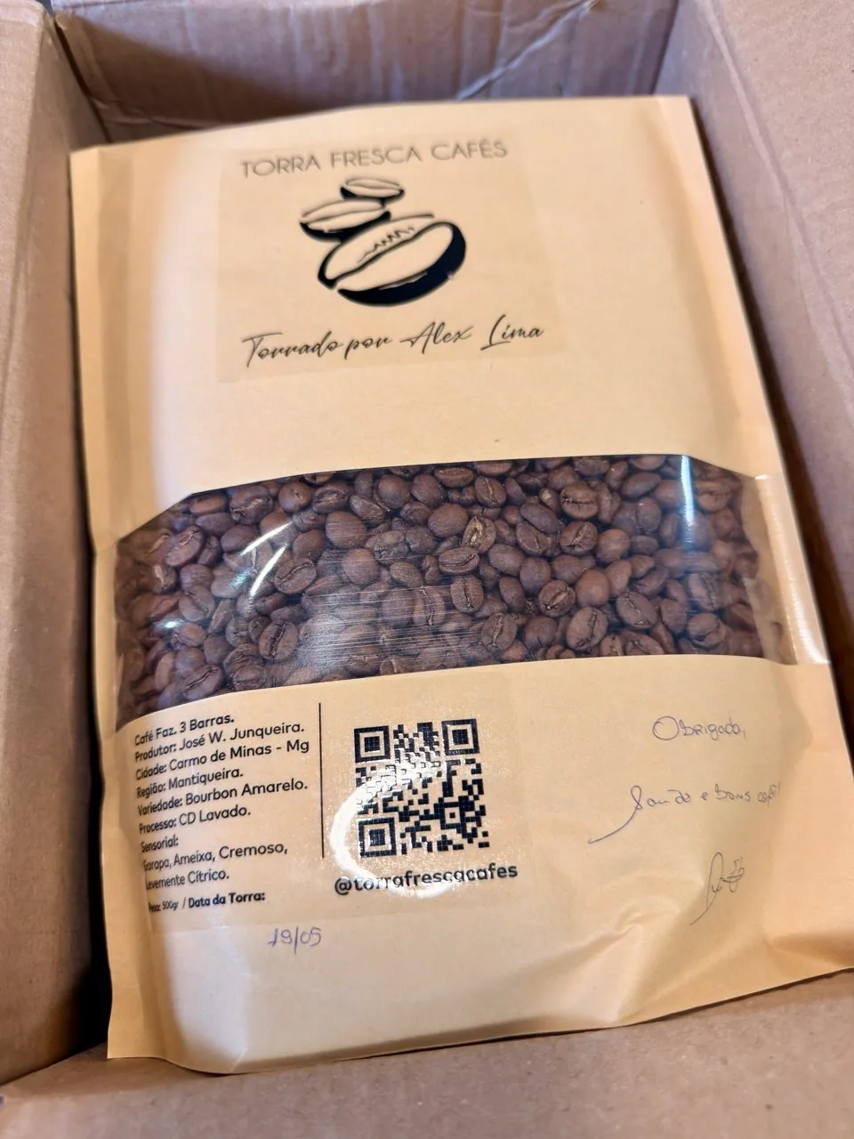 Pacote da Torra Fresca Cafés com grãos visíveis pela janela da embalagem.